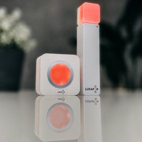 Luxafor Switch Busylight weiss leuchtet rot mit Wuerfel auf dem Tisch